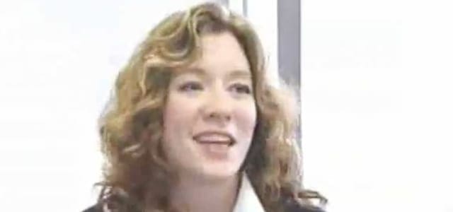 A woman with long hair and a white shirt.