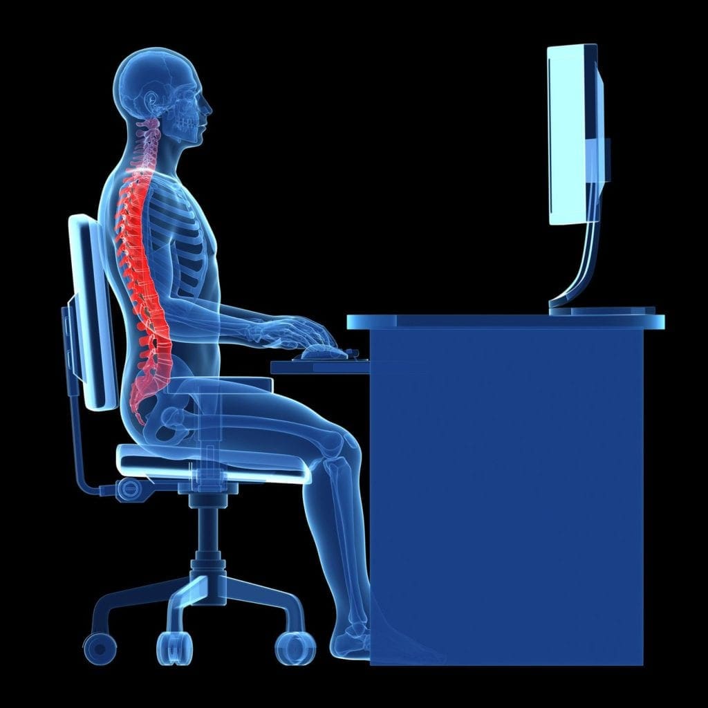 A person sitting at their computer with the back of his neck and shoulder bent over.