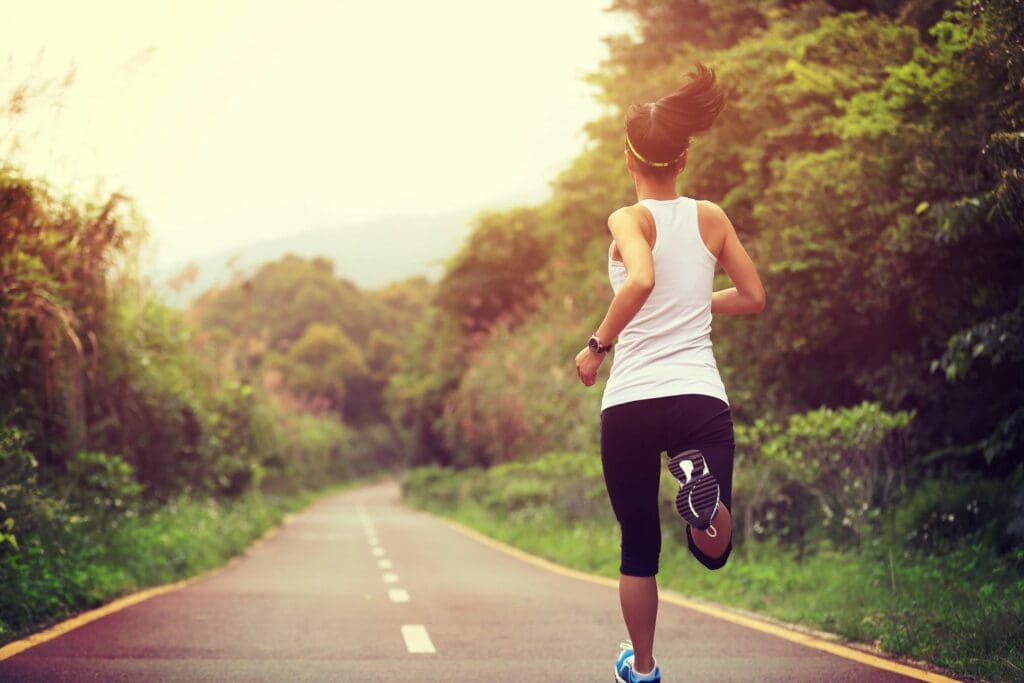 A woman running down the middle of a road.