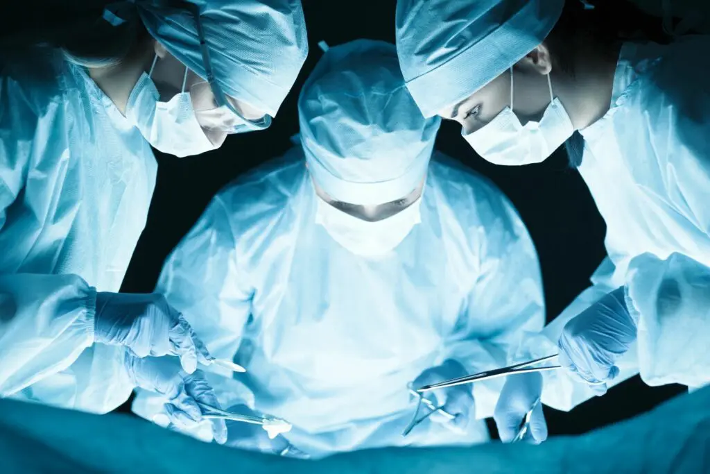 A group of surgeons performing surgery in the dark.