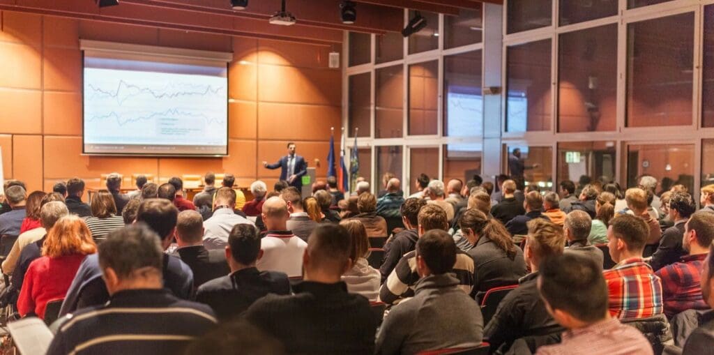 A large group of people in front of a projector screen.