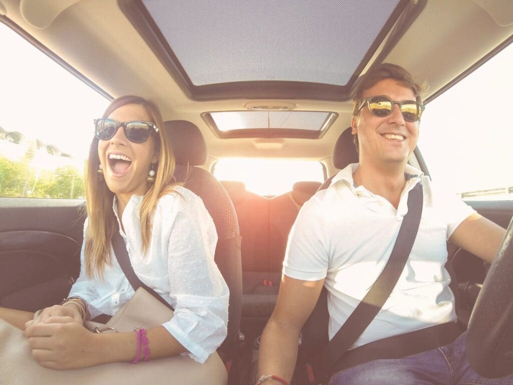 A man and woman sitting in the back of a car.