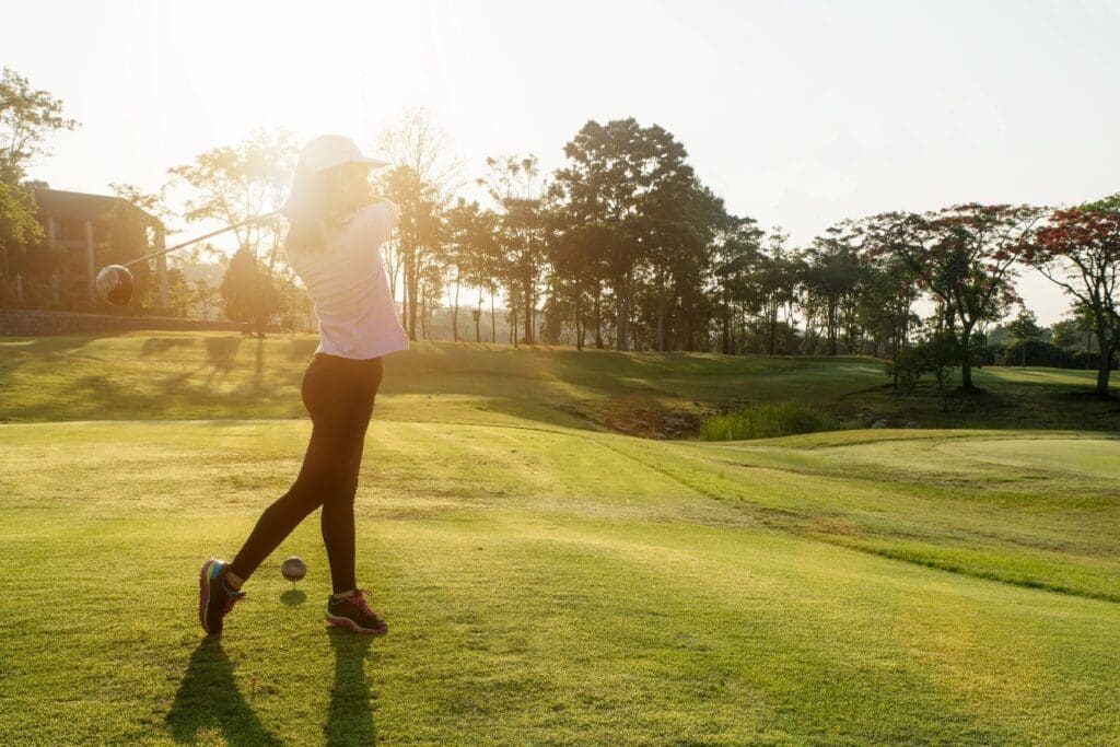 A woman is playing golf on the green.