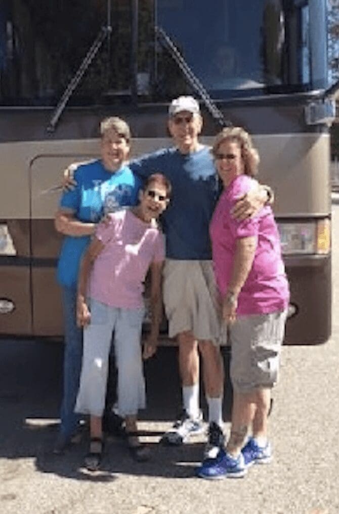 A family posing for the camera in front of their rv.